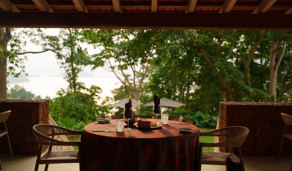 Table set for lunch on a shaded Belo Monte terrace with rainforest and ocean views