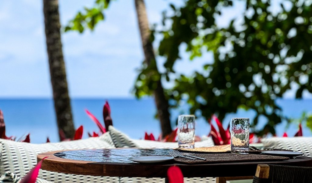 Outdoor dining area with ocean view at Bom Bom Beach Resort.