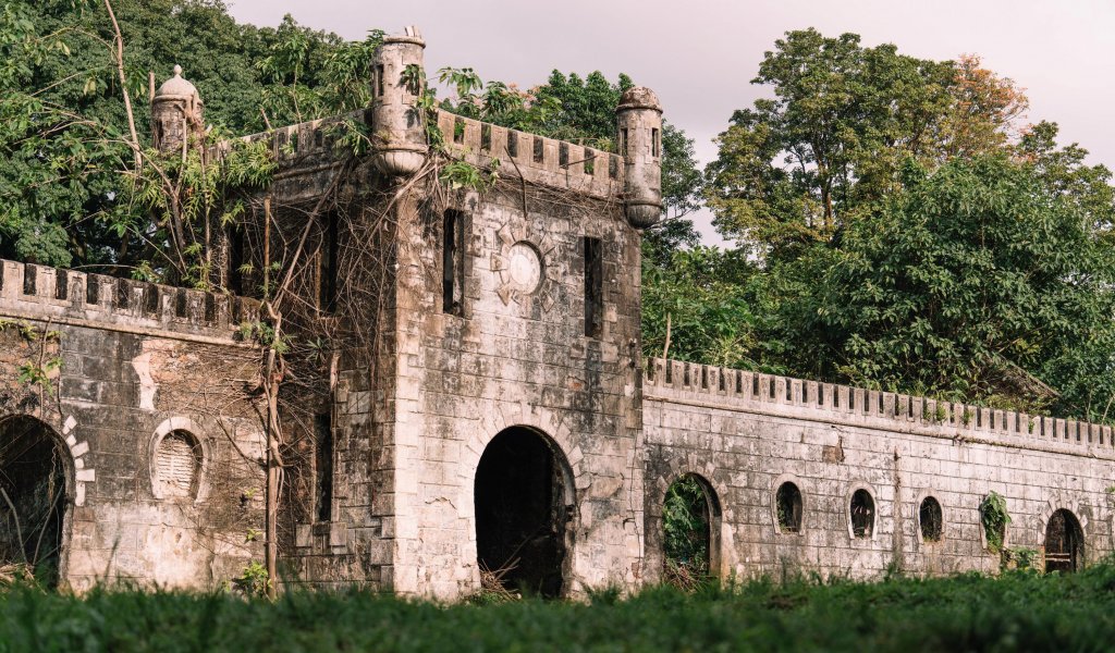 Ruins of an old stone building surrounded by lush greenery