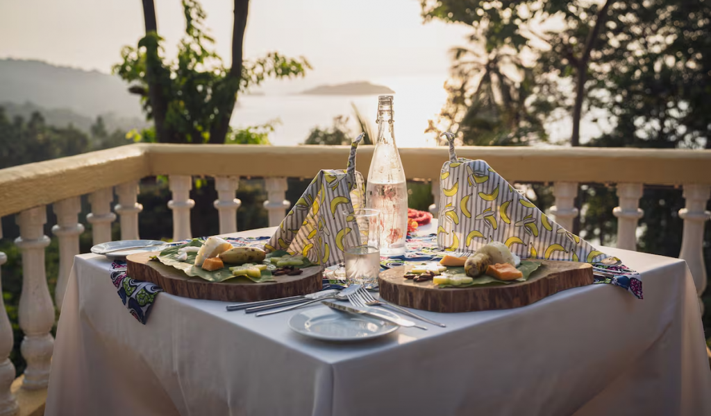 Terrace dining at Belo Monte at sunset, island views and tasting plates served on wooden boards.