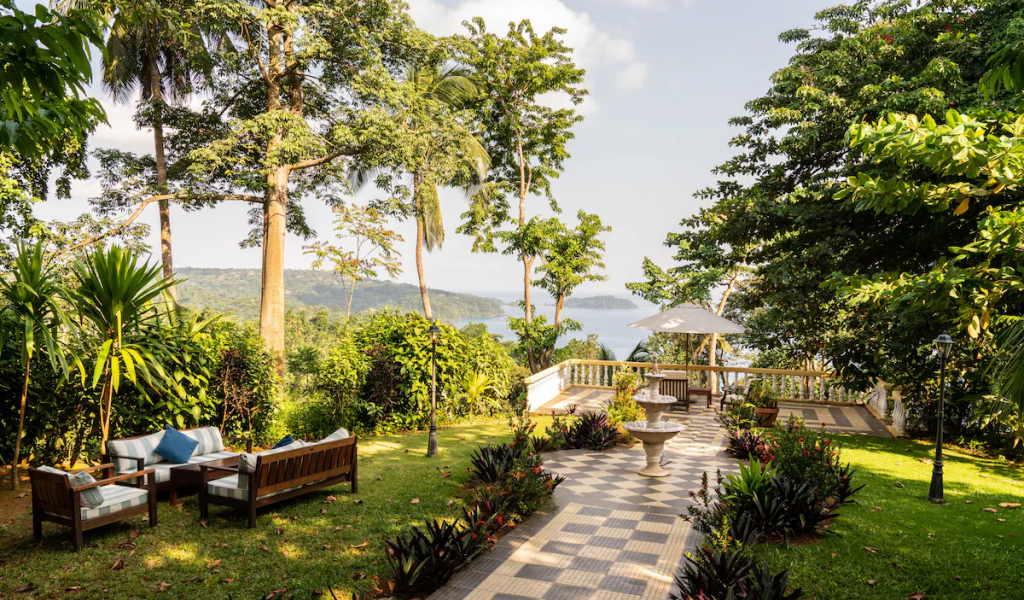 Garden terrace at Belo Monte with checkerboard path, fountain and lounge seating, overlooking the bay on Príncipe Island.