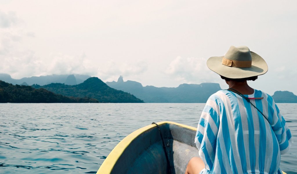 Woman on a small boat facing forward toward Príncipe Island
