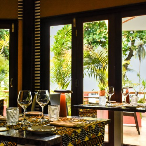 Dining area with tables, chairs, and umbrellas at Omali Restaurant, São Tomé