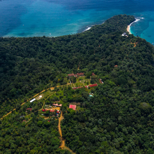 Aerial view of Belo Monte on Príncipe Island, plantation house nestled in rainforest between turquoise bays and beaches.