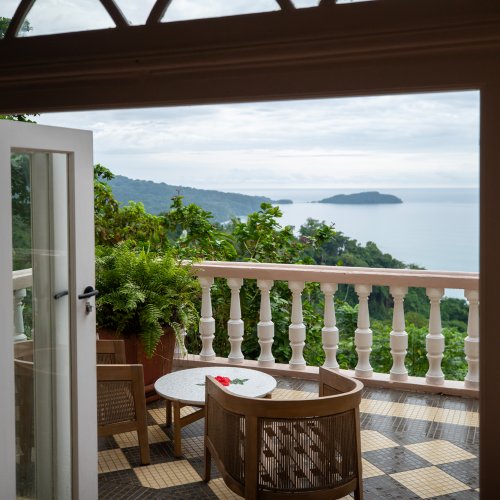 View from a Belo Monte room through French doors onto a terrace with sea and island views