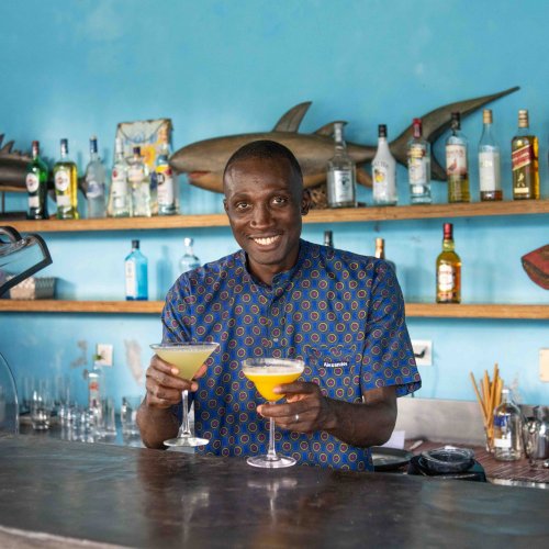 Barman a servir dois cocktails tropicais no bar do Omali, Ilha de São Tomé