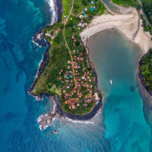 Vista aérea vertical da aldeia de Água Izé numa península rodeada por águas turquesa, Ilha de São Tomé