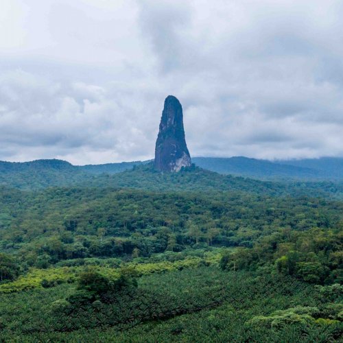 Vista panorâmica do Pico Cão Grande erguendo-se acima da densa floresta tropical, Ilha de São Tomé