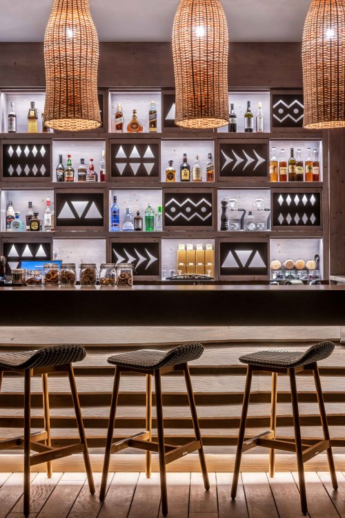 A drinks bar with bottles on shelves at Sundy Praia