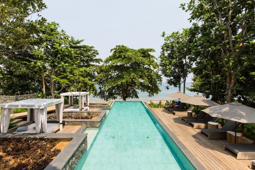 Piscina longa e turquesa com espreguiçadeiras de cada lado mar ao fundo at Sundy Praia