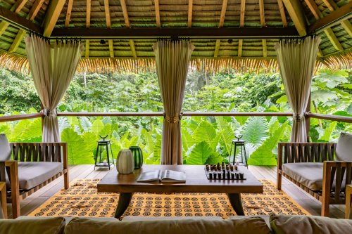 Elevated covered area with seating, table, and chess game at Sundy Praia
