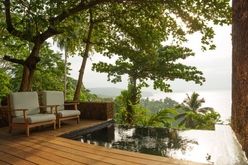 Private plunge pool and deck with armchairs overlooking the rainforest and ocean at Belo Monte