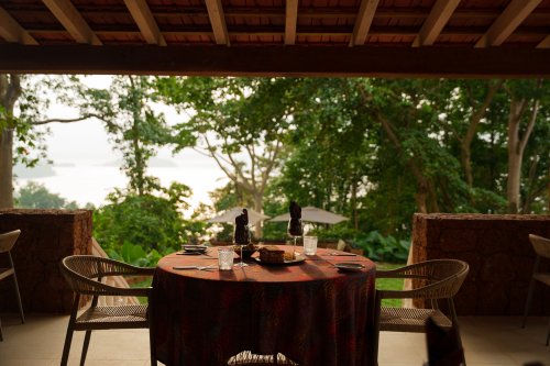 Table set for lunch on a shaded Belo Monte terrace with rainforest and ocean views