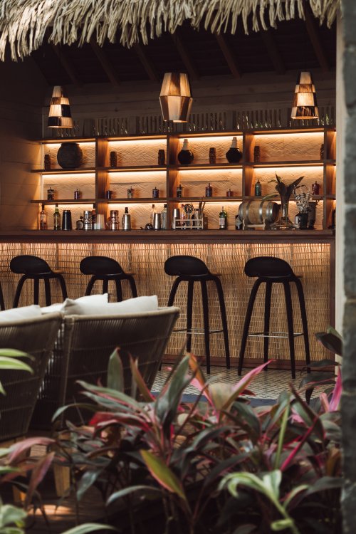 Close-up of bar with stools and illuminated shelving at Bom Bom Beach Club