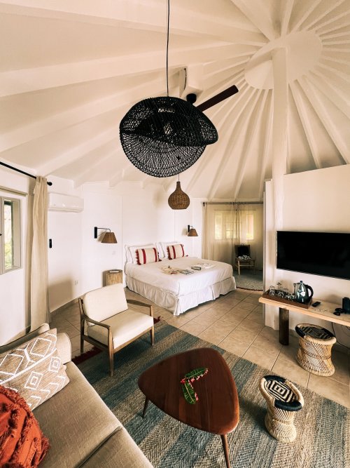 Quarto vibrante com cama, sofá e área de TV no Bom Bom Beach Resort.