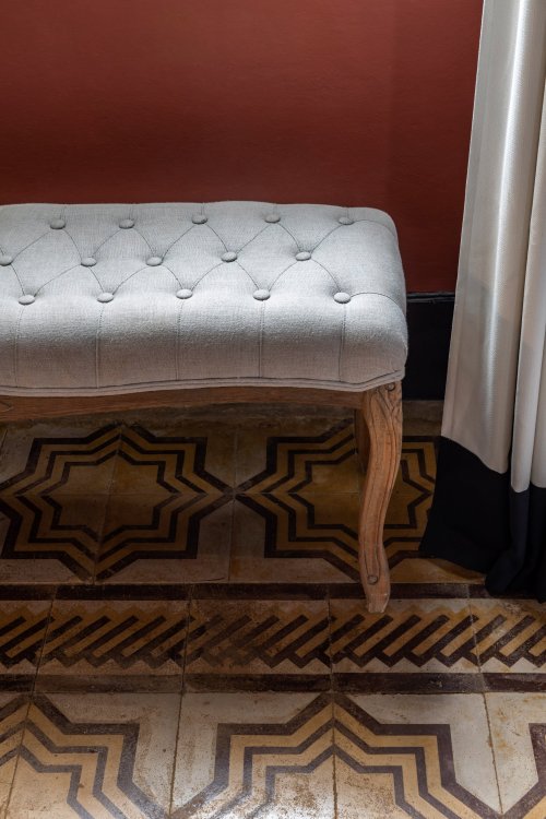Close-up of a tufted bench and decorative patterned tiles at Roça SundyClose-up de um banco acolchoado e azulejos decorativos com padrões na Roça Sundy