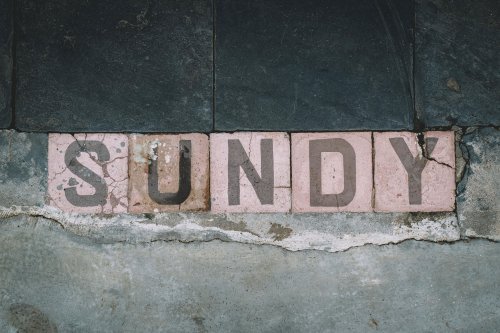 Letras de madeira formando "Sundy" na Roça Sundy