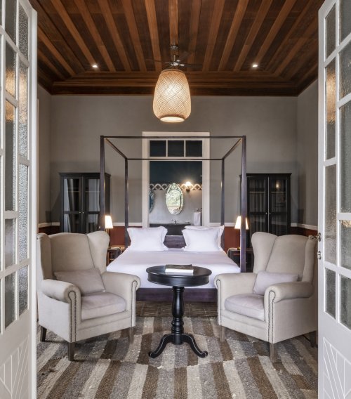 Suite espaçosa na Eclipse House na Roça Sundy com cama dossel, poltronas e teto de madeira