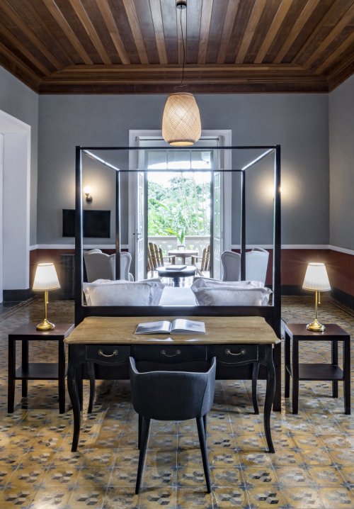 Spacious suite at Eclipse House in Roça Sundy with a four-poster bed, desk, and wooden ceiling