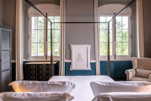 Suite iluminada na Eclipse House na Roça Sundy com cama dossel e vista para o jardim