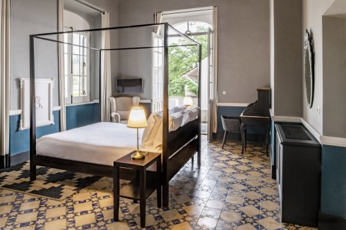 Suite espaçosa na Eclipse House na Roça Sundy com cama dossel, secretária e teto de madeira