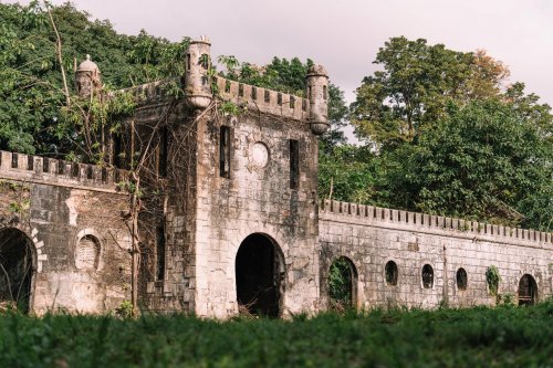 Ruins of an old stone building surrounded by lush greenery