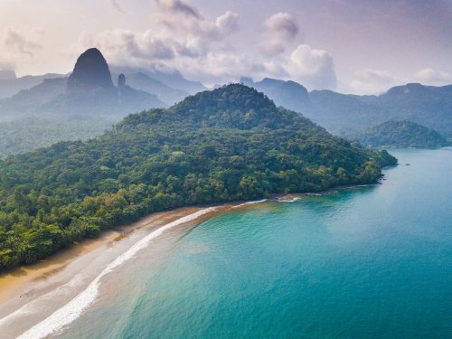 Vista aérea de uma praia isolada com floresta densa na Ilha de São Tomé