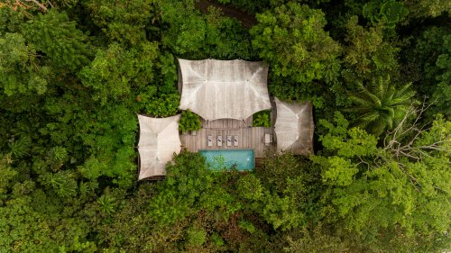 Aerial view of the Sundy Praia Pool Villa with private pool and wooden deck, nestled within the tropical rainforest, Príncipe Island