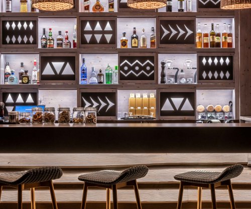 A drinks bar with bottles on shelves at Sundy Praia