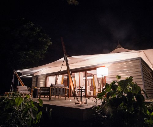 Uma vila iluminada por dentro com terraço à noite at Sundy Praia