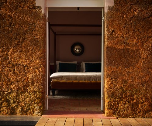 Entrada em pedra para a Suite com Piscina Privativa do Belo Monte com cama de dossel ao fundo