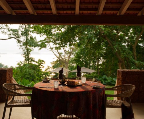 Table set for lunch on a shaded Belo Monte terrace with rainforest and ocean views
