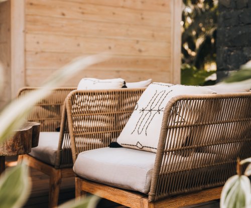 Par de cadeirões de vime com almofadas estampadas no deck do Bom Bom Beach ClubPar de cadeirões de vime com almofadas estampadas no deck do Bom Bom Beach Club