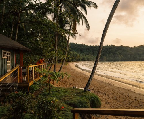 Vista da praia ao amanhecer com luz dourada suave no Bom Bom Resort.