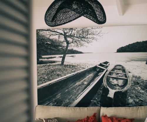 Lâmpada preta e arte na parede de um quarto no Bom Bom Beach Resort.