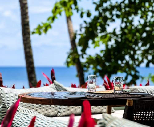 Outdoor dining area with ocean view at Bom Bom Beach Resort.