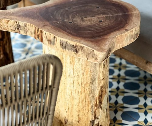 Wooden table with natural finish in a lounge area at Bom Bom Beach Resort.