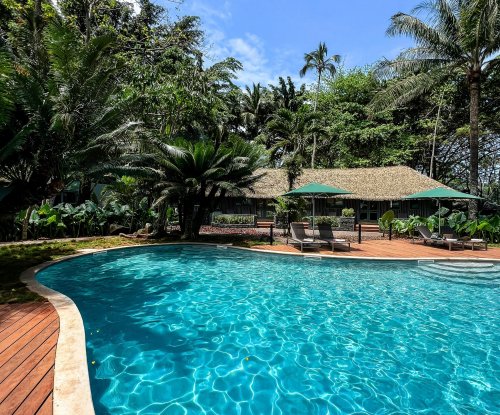 Piscina rodeada por vegetação exuberante no Bom Bom Beach Resort.