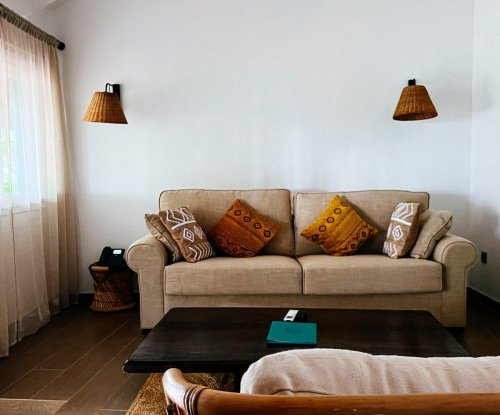 Living area with two beige sofas in a bedroom at Bom Bom Beach Resort.