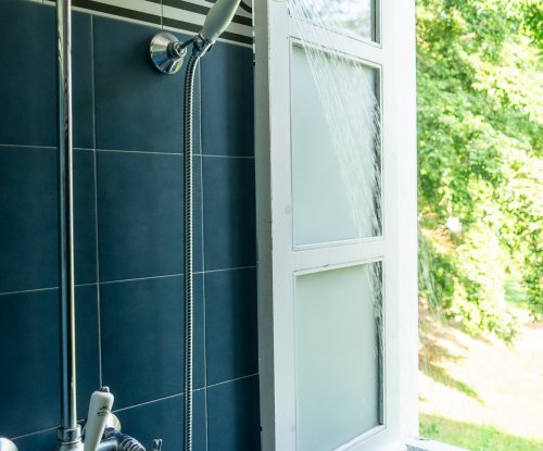 Shower in the bathroom at Roça Sundy suite with an open window