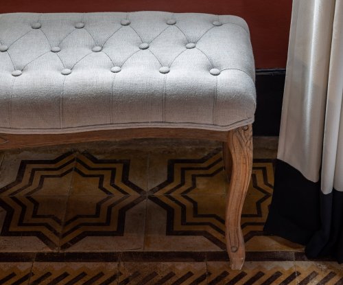 Close-up of a tufted bench and decorative patterned tiles at Roça SundyClose-up de um banco acolchoado e azulejos decorativos com padrões na Roça Sundy