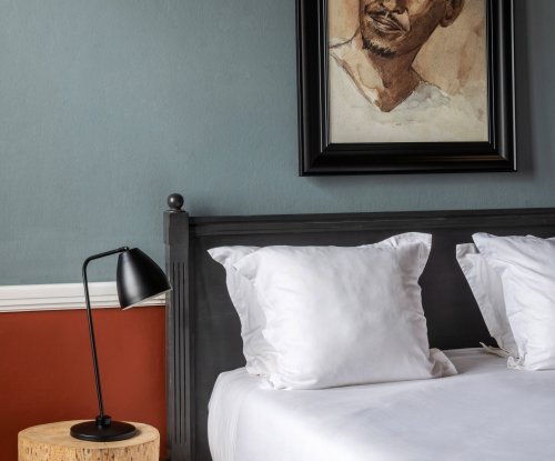 Quarto espaçoso com grandes janelas e design vintage no Roça Sundy Boutique Hotel.