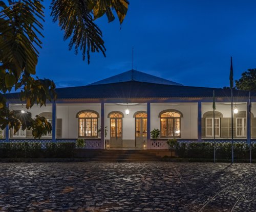 Exterior view of the illuminated Eclipse House at Roça Sundy at night