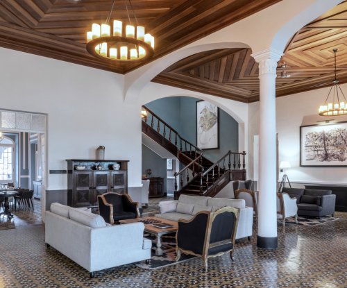 Receção e lobby espaçosos na Eclipse House na Roça Sundy com mobiliário elegante e teto de madeira