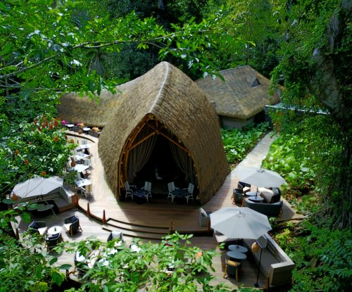 Top view of OKA Sundy Restaurant deck in the forest at Sundy Praia, shaded seating for open-air dining