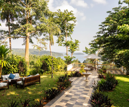 Garden terrace at Belo Monte with checkerboard path, fountain and lounge seating, overlooking the bay on Príncipe Island.