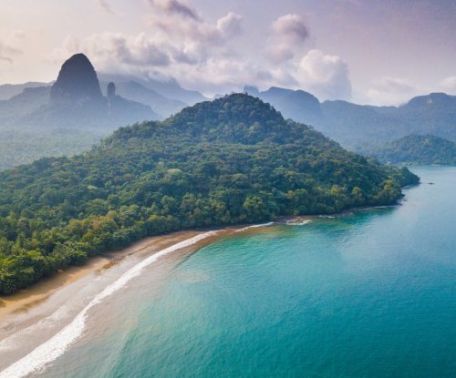 Vista aérea de uma praia isolada com floresta densa na Ilha de São Tomé
