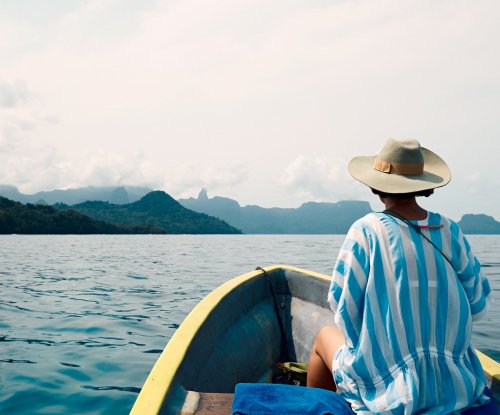 Woman on a small boat facing forward toward Príncipe Island