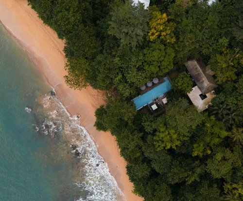 Aerial view of Sundy Praia beach and pool hidden in the forest on Príncipe Island, steps from the shoreline