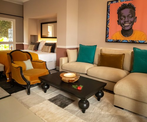 Belo Monte suite with a lounge sofa, framed portrait and the bed in the background